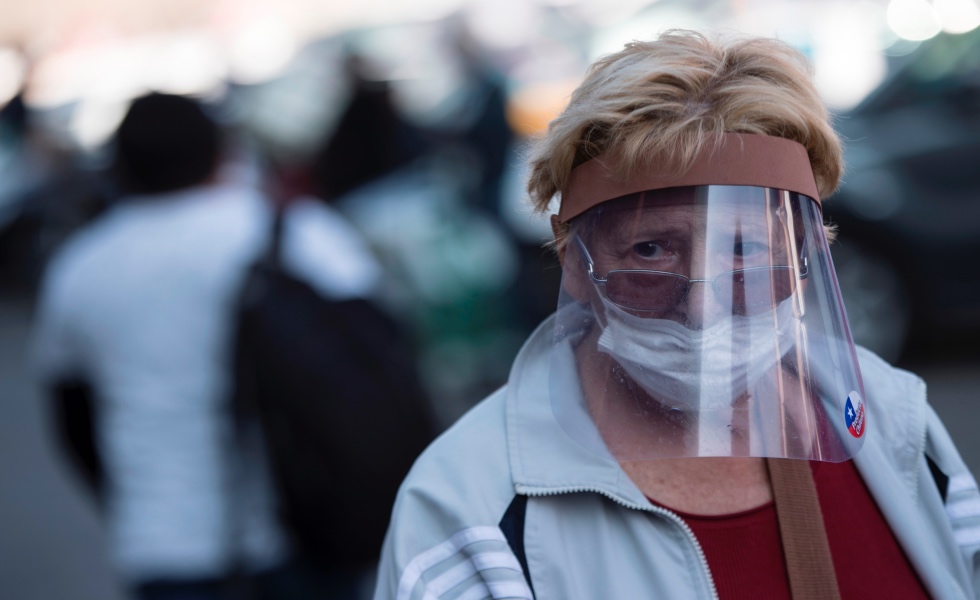 Una mujer con tapabocas y protector entra el 14 de mayo de 2020 a la Vega Central, principal mercado de abastos de Santiago (Chile). EFE/Alberto ValdÈs/Archivo