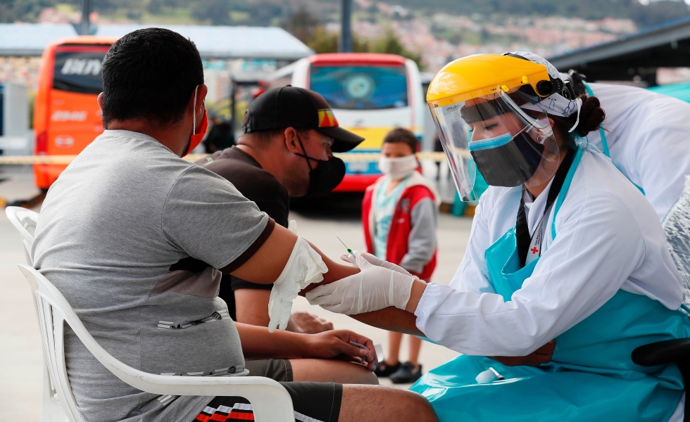 BOG400. BOGOT¡ (COLOMBIA), 03/07/2020.- Una integrante de la Cruz Roja toma este viernes una prueba r·pida de tamizaje para COVID-19 a un migrante venezolano en Bogot· (Colombia). M·s de 300 migrantes venezolanos que permanecÌan acampando sobre una autopista fueron trasladados a los parqueaderos de La Terminal del Norte donde cuentan con servicio de baÒos y una brigada de salud mientras pueden salir rumbo a Venezuela. EFE/ Carlos Ortega