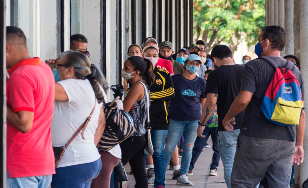 ACOMPAÑA CRÓNICA: CORONAVIRUS VENEZUELA - AME5847. MARACAIBO (VENEZUELA), 11/06/2020.- Fotografía del pasado 7 de junio que muestra a un grupo de personas en fila para entrar a un local comercial en Maracaibo (Venezuela). Como todos los males de Venezuela, el coronavirus se ha ensañado con Maracaibo, la otrora urbe pujante que lleva años castigada por la crisis y ahora está condenada a una cuarentena radical para intentar detener el contagio de una "cepa más peligrosa" que ha matado más rápido que en el resto del país. "Tenemos los (números) más altos de mortalidad", dijo en una declaración el gobernador del estado Zulia (oeste), el chavista Omar Prieto, al ofrecer un balance sobre la pandemia por COVID-19 en esa región que registra 183 contagiados y seis fallecidos, de un total de 23 que se computan en todo el país. EFE/ Henry Chirinos