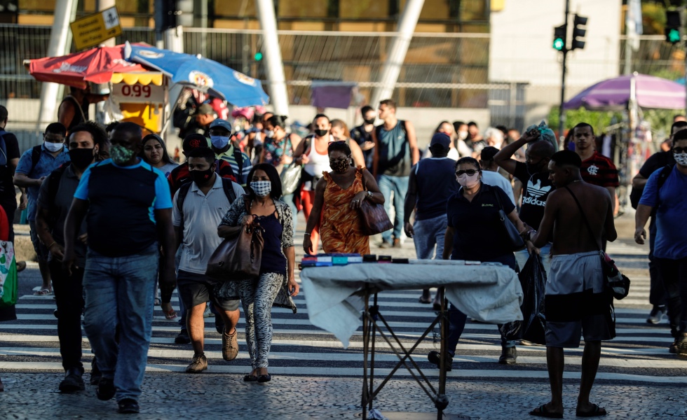 Personas con mascarillas para prevenir la propagación del coronavirus cruzan una calle en Río de Janeiro (Brasil). EFE/Antonio Lacerda/Archivo