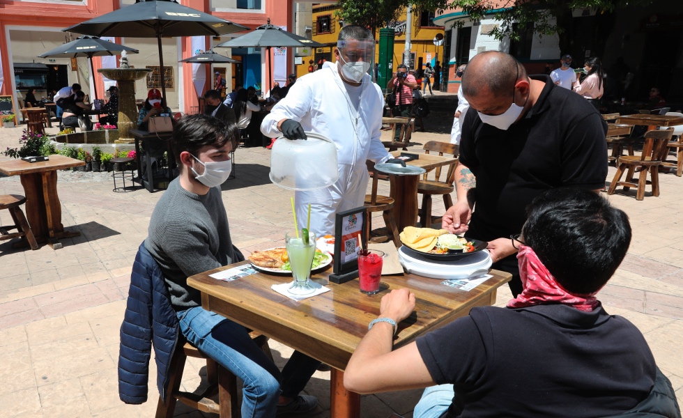 Un grupo de personas consume alimentos al aire libre en la plaza del Chorro de Quevedo en Bogotá (Colombia). EFE/ Carlos Ortega/Archivo