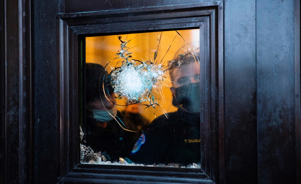 -FOTOGALERIA- EA3075. WASHINGTON (ESTADOS UNIDOS), 06/01/2021.- Dos policÌas observan a travÈs del vidrio roto de una de las puertas del Capitolio de Estados Unidos, luego de que seguidores de Donald Trump irrumpieran en el recinto durante unas protestas hoy, en Washington (Estados Unidos). Los manifestantes a favor de Donald Trump irrumpieron en el Capitolio de los Estados Unidos donde tuvo lugar la certificaciÛn de voto del Colegio Electoral para el Presidente electo Joe Biden. EFE/ MICHAEL REYNOLDS