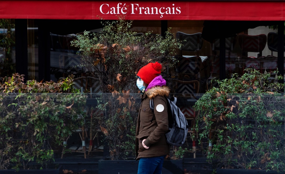 Paris (France), 14/01/2021.- A pedestrian wearing a protective face mask walks past the 'Cafe Francais', closed during business hours as part of restrictive measures set to tackle the surging number of coronavirus disease (COVID-19) cases in France, in Paris, France, 14 January 2021. French Prime Minister Castex is due to hold a press conference on 14 January to announce possible extended measures to further combat the rising number of COVID-19 cases, including the English variant, which appeared in isolated clusters around the country. (Francia) EFE/EPA/IAN LANGSDON
