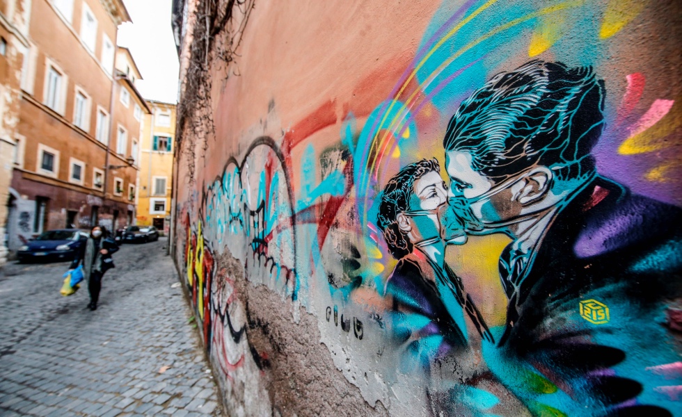 Rome (Italy), 15/01/2021.- People walk past graffiti depicting a couple kissing as wearing protective masks, in Trastevere district, Rome, Italy, 15 January 2021. (Italia, Roma) EFE/EPA/FABIO FRUSTACI