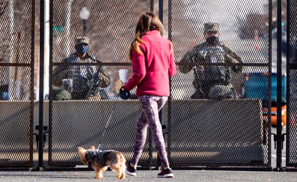 Washington (United States), 16/01/2021.- National Guard troops stand guard as a woman walks her dog past at the fence line around the US Capitol building in Washington, DC, USA, 16 January 2021. At least twenty thousand troops of the National Guard and other security measures are being deployed in Washington to help secure the Capitol area in response to potentially violent unrest around the inauguration of US President-elect Joe Biden. (Estados Unidos) EFE/EPA/JUSTIN LANE