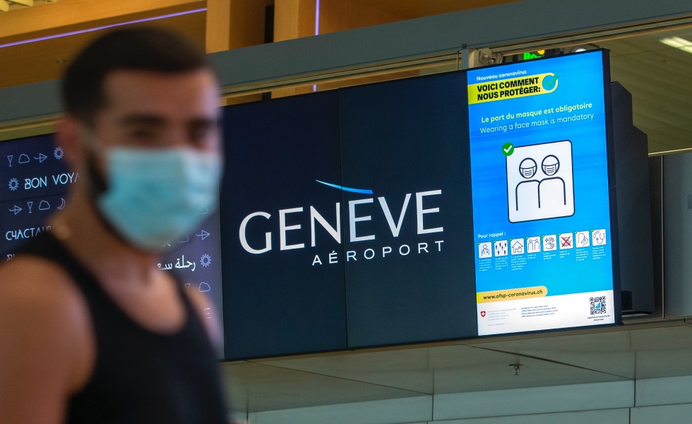 Geneva (Switzerland), 28/07/2020.- Passengers wearing face masks walk in front an information screen reading 'wearing masks is mandatory' at the Geneve Airport in Geneva, Switzerland, 28 July 2020. From 28 July on, wearing of a face mask is compulsory at Geneva Airport to fight against the spread of coronavirus COVID-19 pandemic. (Suiza, Ginebra) EFE/EPA/SALVATORE DI NOLFI