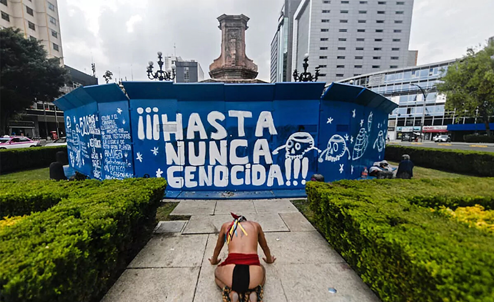 Un indígena frente a la valla que rodea el pedestal vacío, en Ciudad de México.
Foto @jatirado_oc